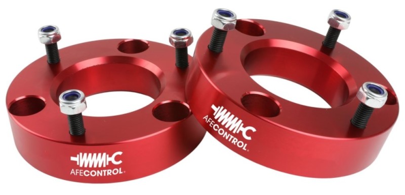 aFe CONTROL 2.0 IN Leveling Kit for 2004-2021 Ford F-150 in red, featuring aluminum spacers and hardware for installation.