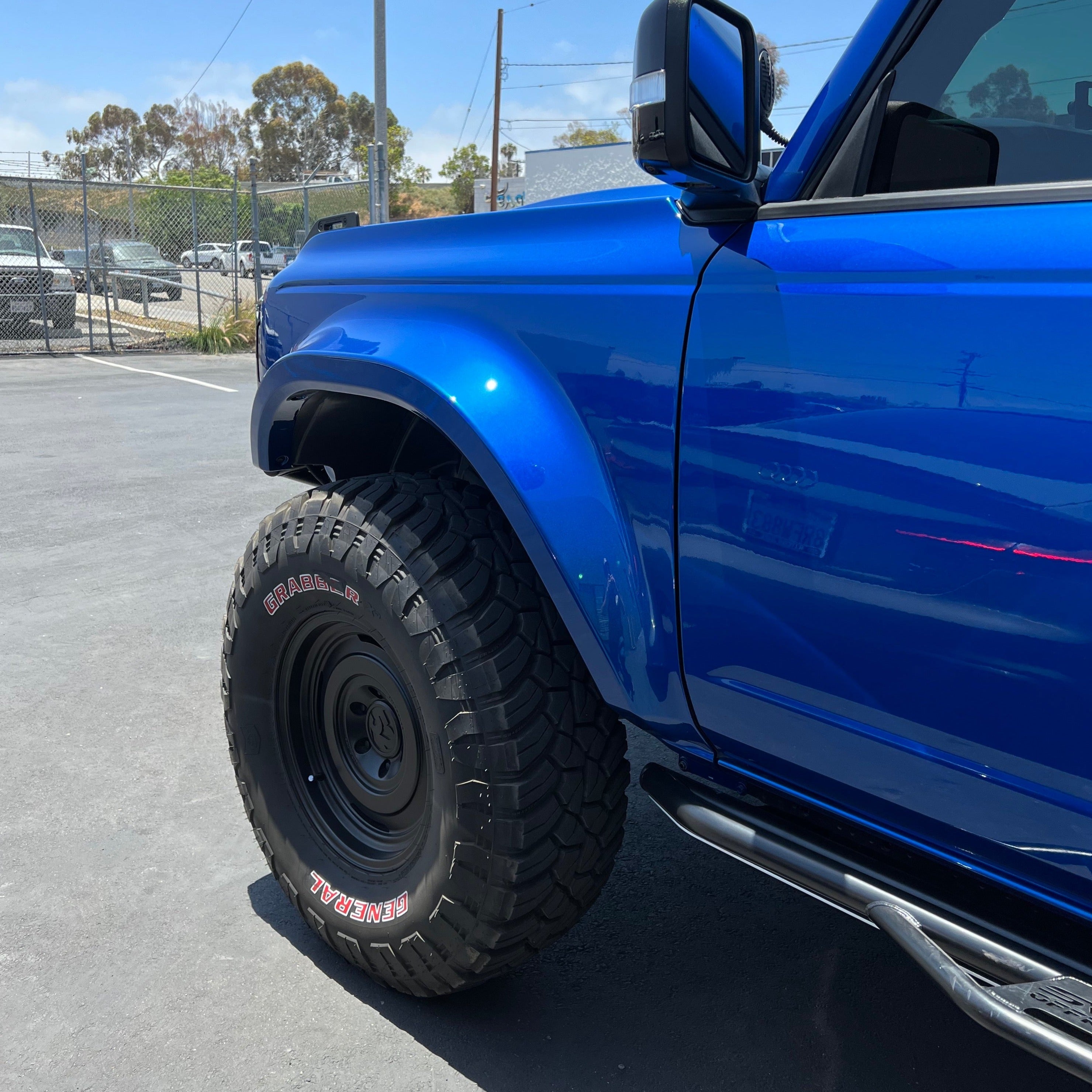 2021-2024 Ford Bronco fenders showcasing a blue SUV with rugged tires, designed for off-road performance and style.