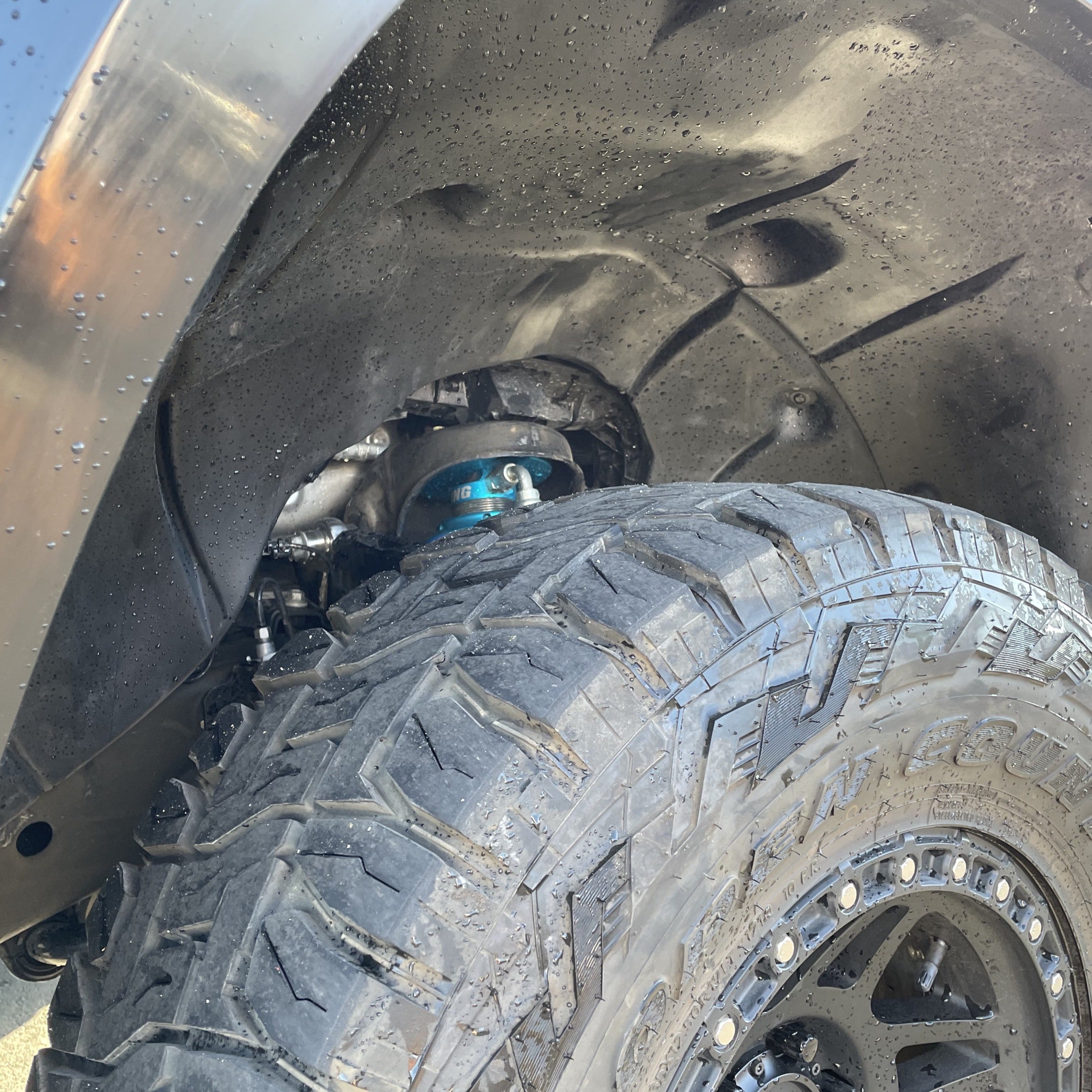 Close-up of a rugged tire and suspension system inside a fender of a 2019-2021 Chevrolet Silverado, showcasing offroad capabilities.