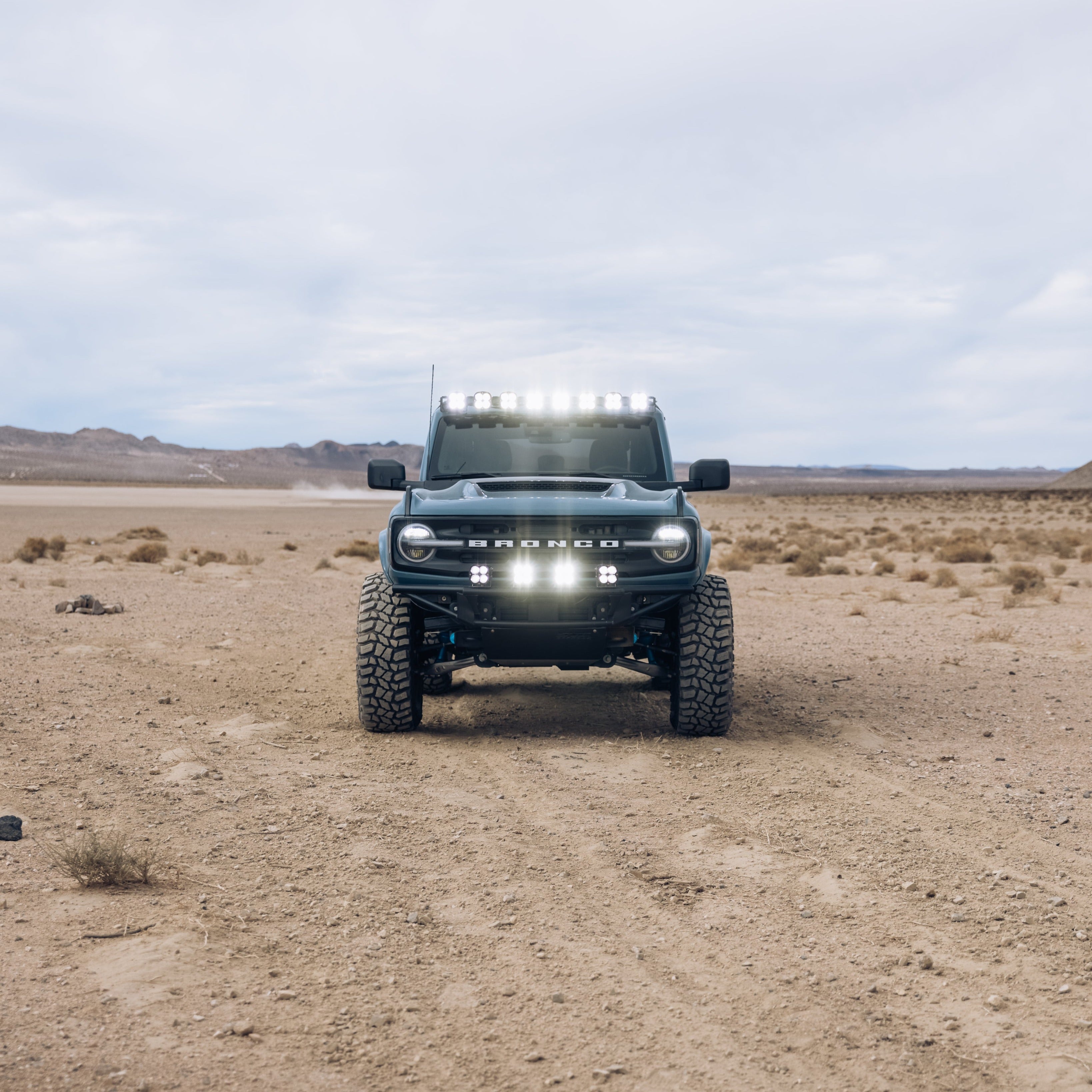 2021-2024 Ford Bronco with a ram air hood, showcasing offroad capabilities in a desert landscape.