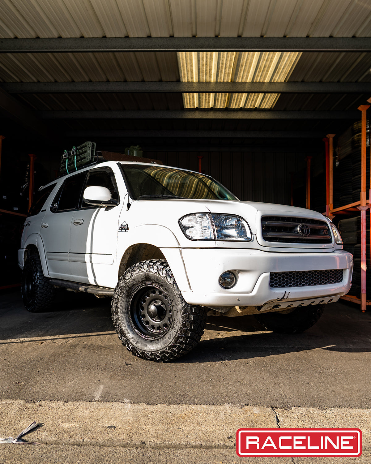 White SUV equipped with 887B Rockcrusher wheels, showcasing an offroad-ready stance in a warehouse setting.
