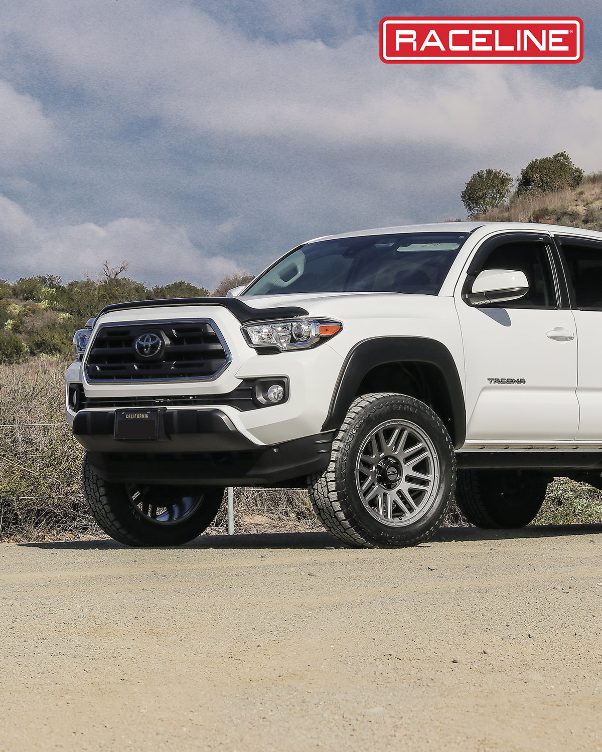 White Toyota Tacoma equipped with 944GS Outlander wheels, showcasing rugged off-road capability on a dirt road.