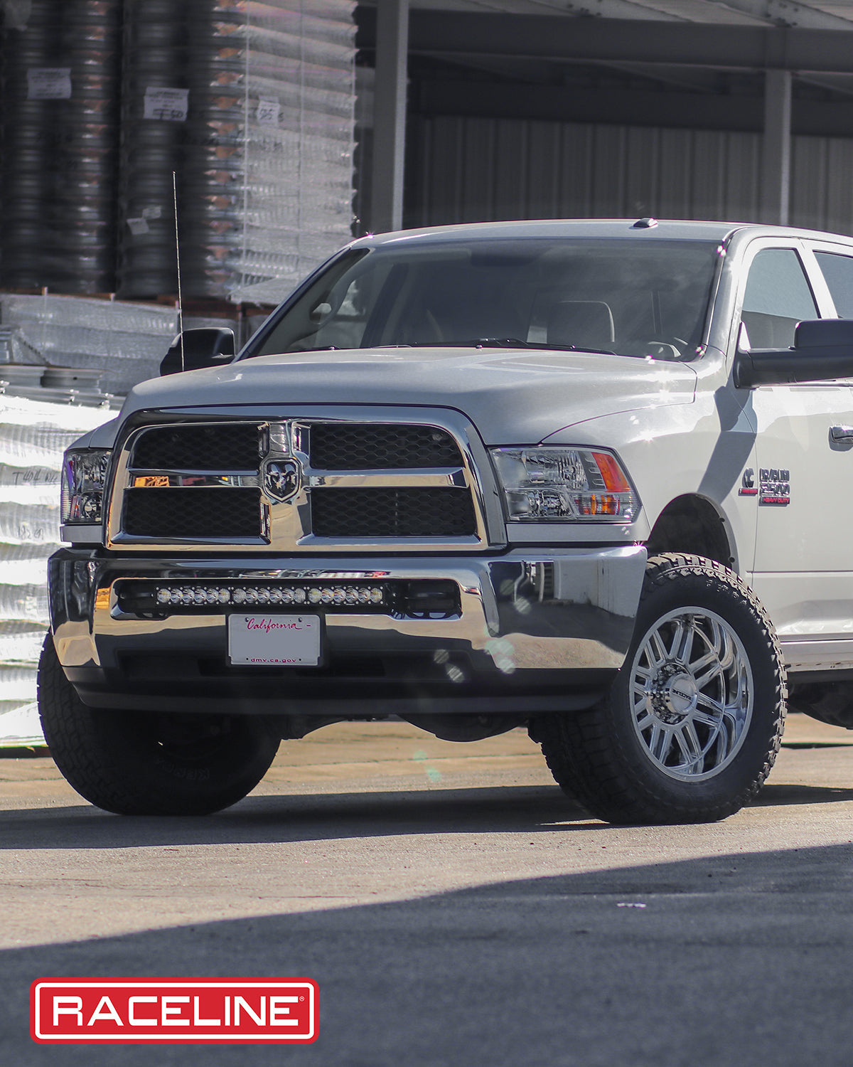 Silver truck featuring Raceline 948C Split wheels, showcasing offroad capability and stylish design in a warehouse setting.