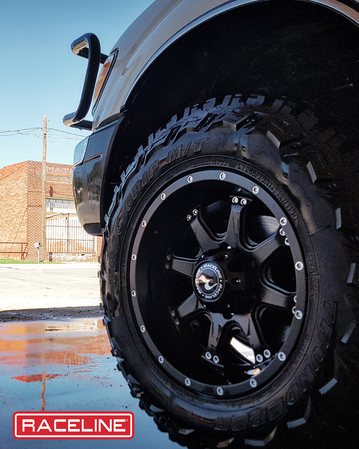 Black Raceline 991B Assault wheel mounted on an off-road tire, showcasing rugged design and traction for adventurous driving.