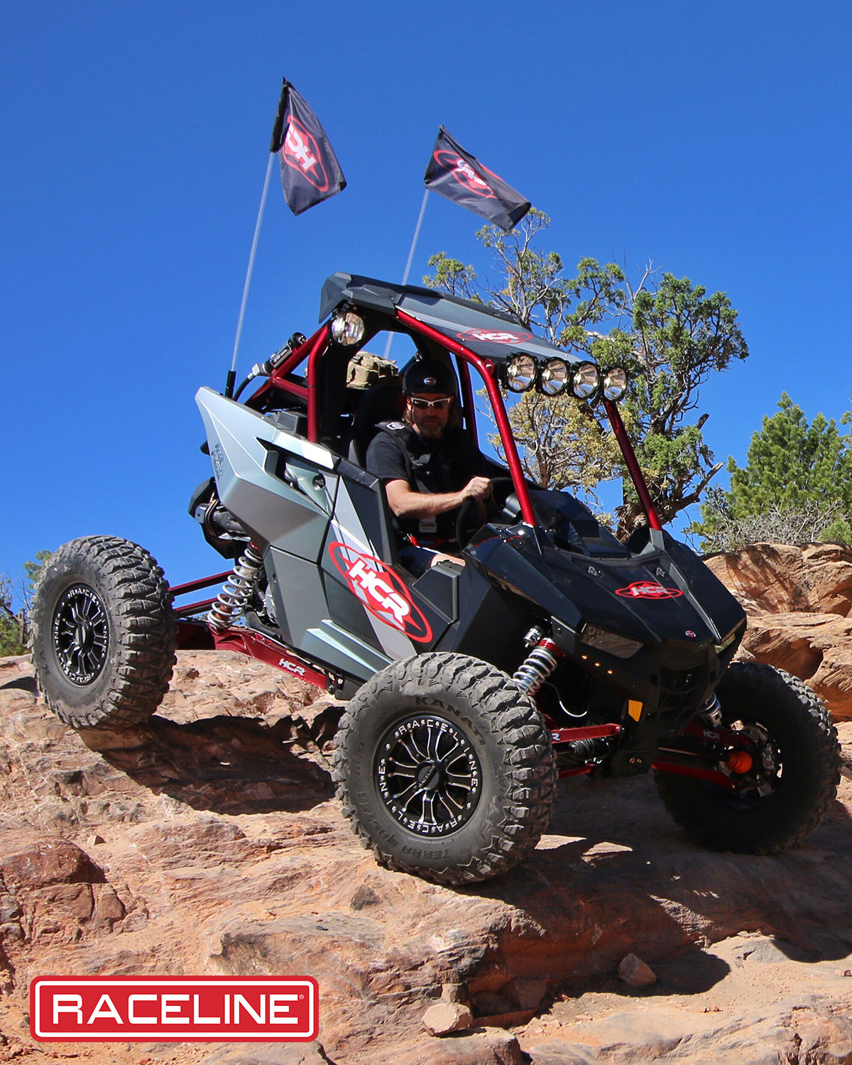 A71MB Mamba Beadlock wheel mounted on a UTV navigating rocky terrain with flags flying. Ideal for offroad enthusiasts.