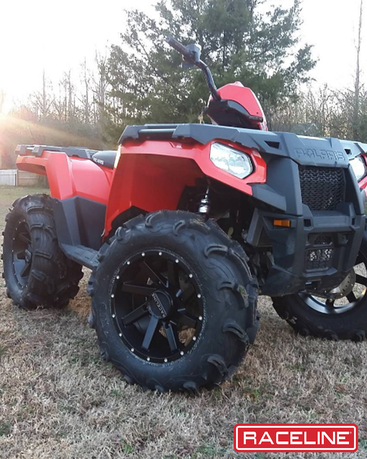 A82B Twist ATV with rugged tires and a striking red body, parked on grass with trees in the background.