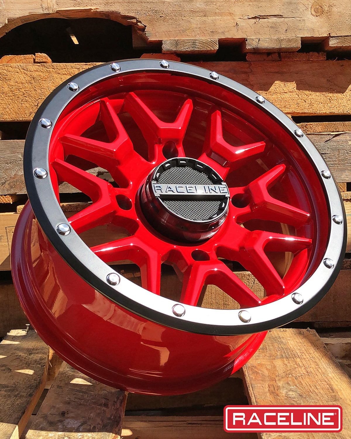 A94R Krank simulated beadlock wheel in vibrant red with a black center cap, showcasing a bold design against a wooden backdrop.