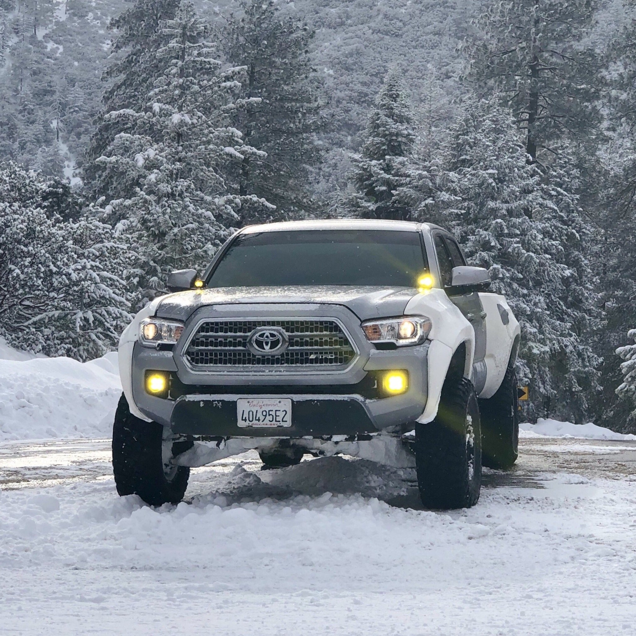 2016-2022 Toyota Tacoma fenders showcased on a lifted truck in a snowy landscape, highlighting off-road capability.