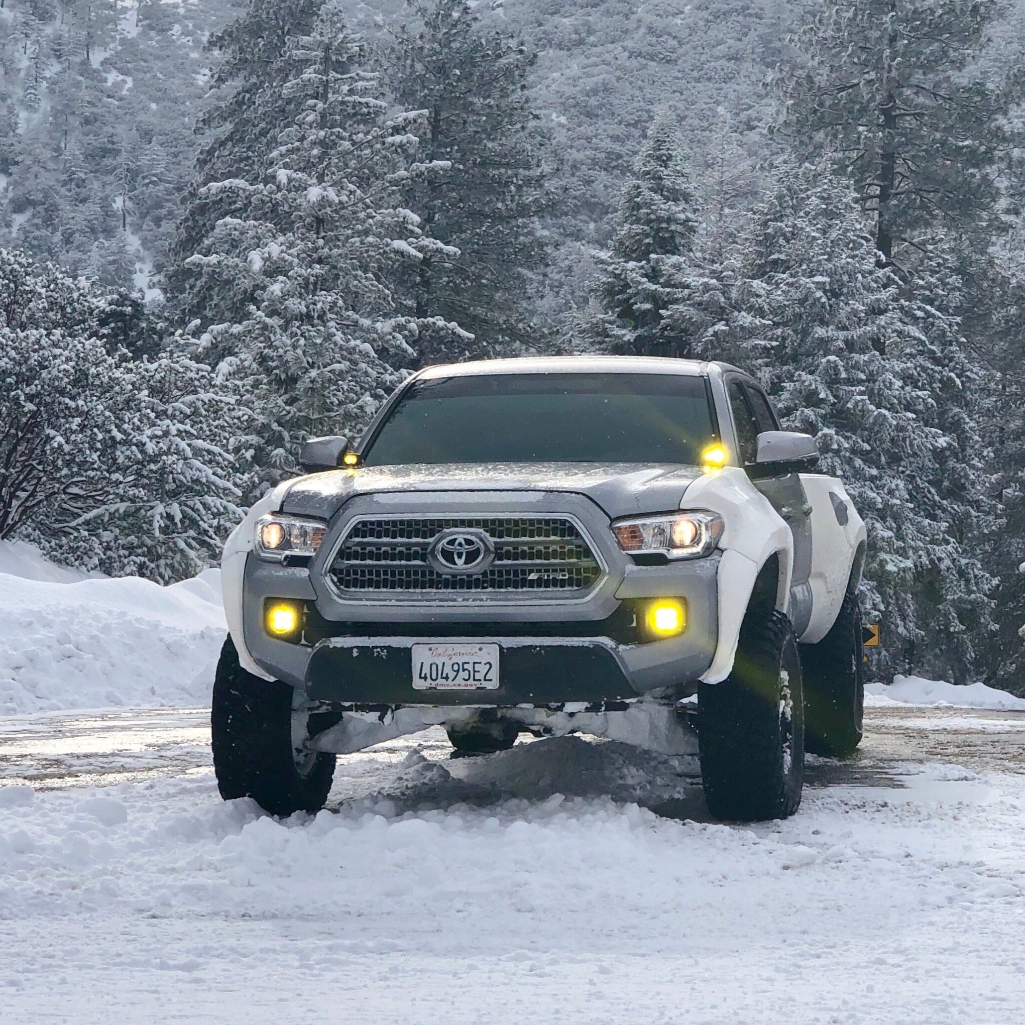 2016-2022 Toyota Tacoma Bedsides installed on a lifted Tacoma in a snowy landscape, showcasing rugged off-road capability.