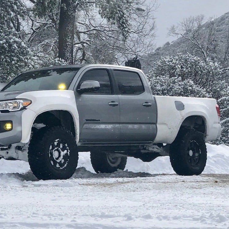 2016-2022 Toyota Tacoma with custom bedsides, showcasing offroad capabilities in a snowy landscape.