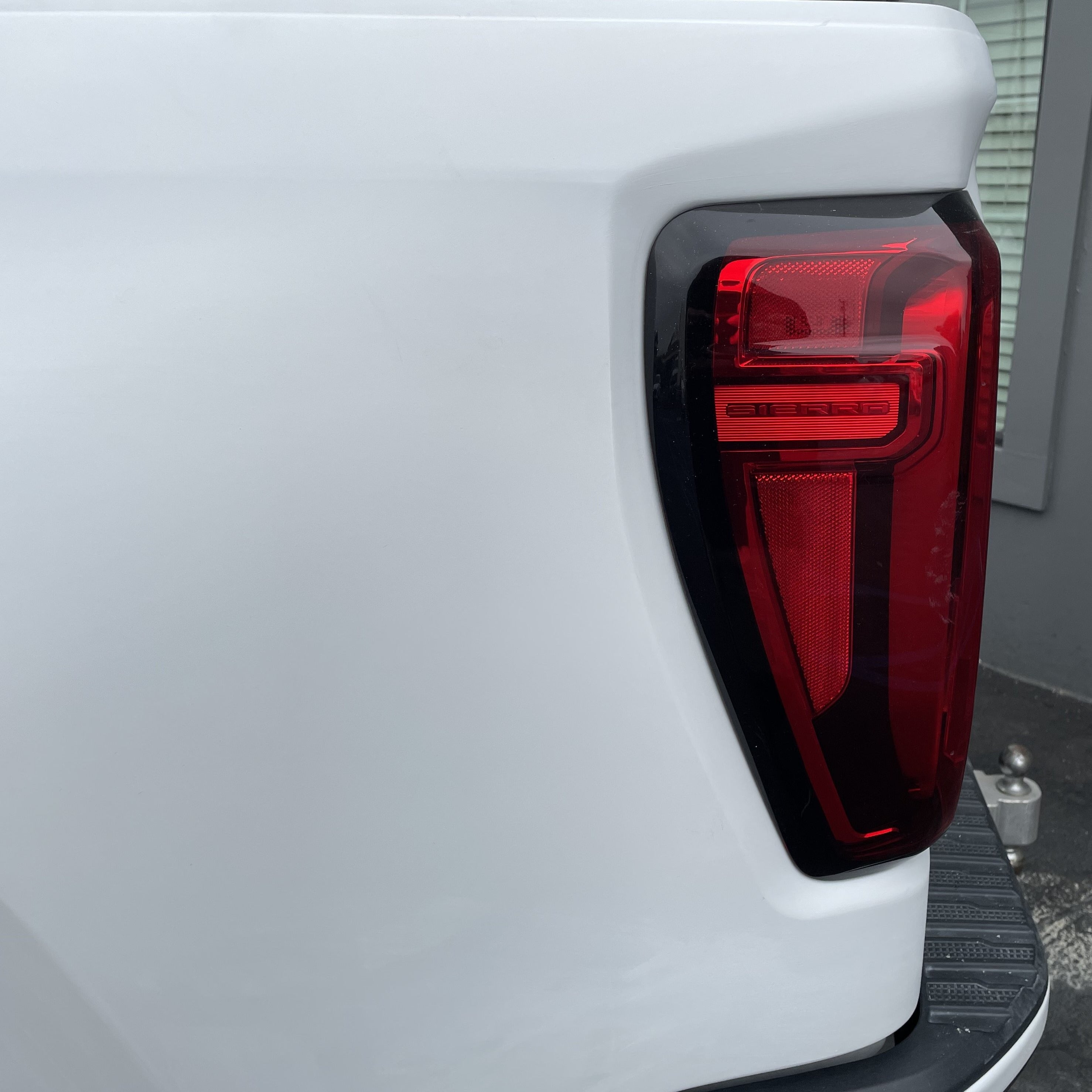 2019-2021 GMC Sierra bedside with a close-up view of the taillight and smooth white finish.