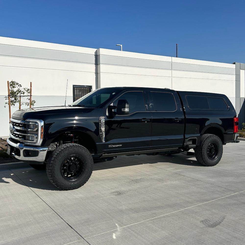 2.5-inch standard lift kit for 2023+ F250/F350 installed on a black truck with off-road tires and a sleek design.