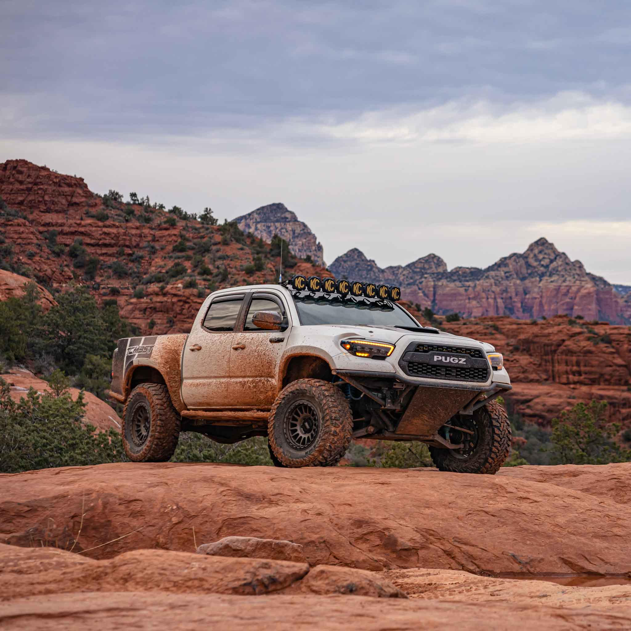 2016-2023 Toyota Tacoma with offroad fenders parked on rocky terrain, showcasing rugged design and outdoor capability.