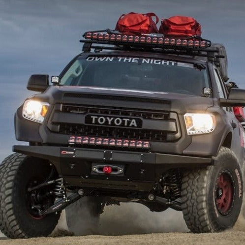 2014-2021 Toyota Tundra with aftermarket fenders, off-roading on rugged terrain, equipped for adventure.