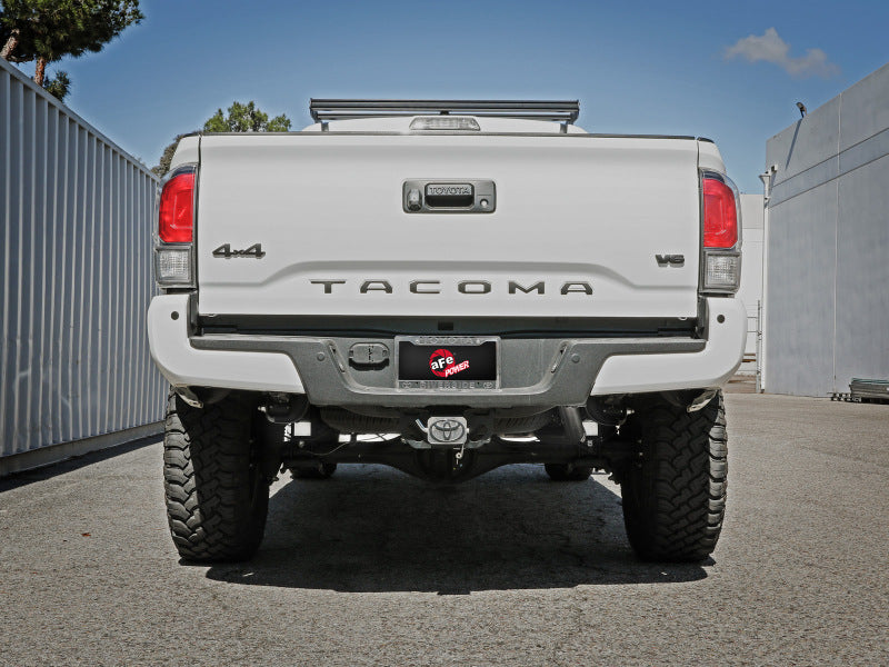 A rear view of a white Toyota Tacoma showcasing the afe MACH Force-Xp tailpipe installed in the exhaust system.