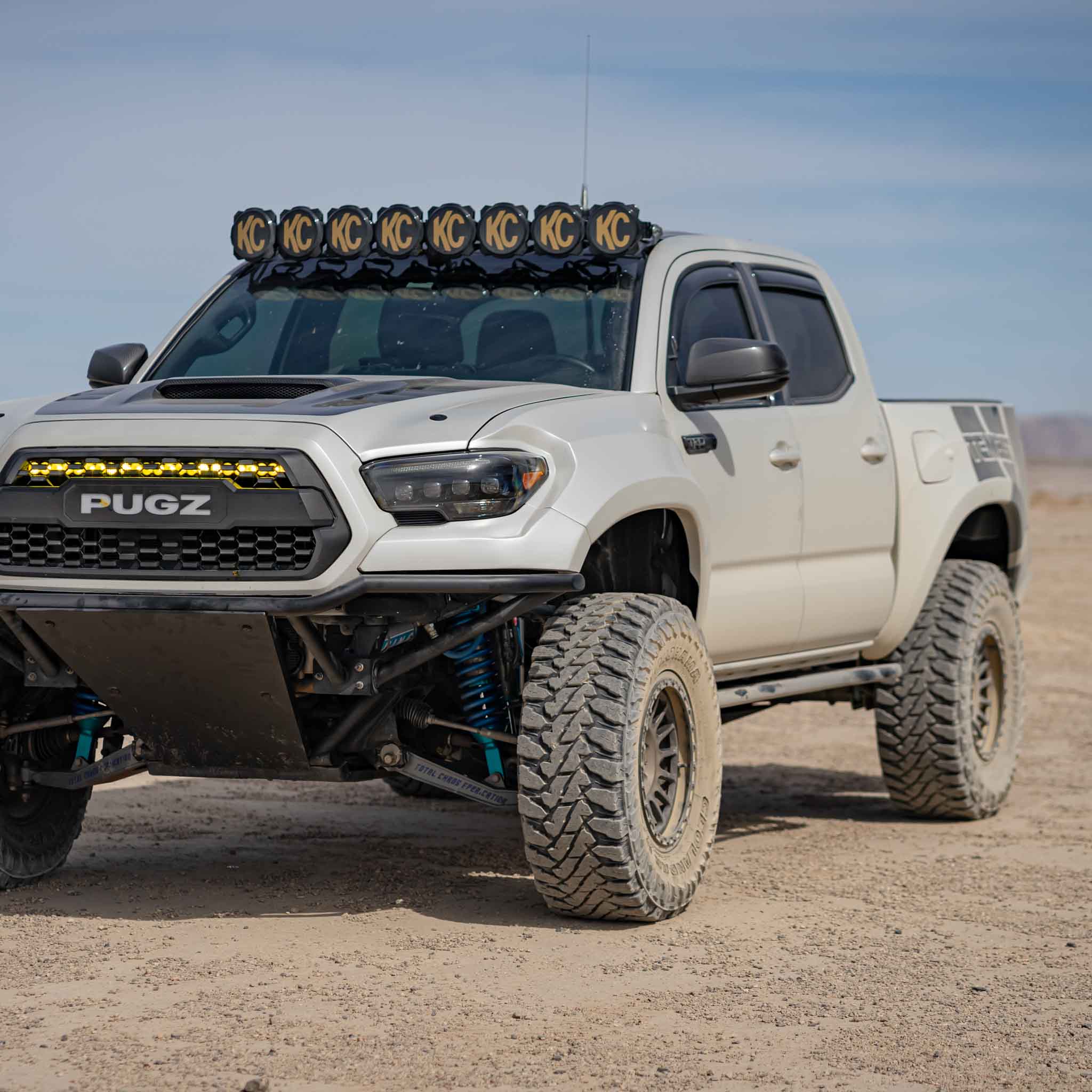 2016-2023 Toyota Tacoma fenders on a modified truck with offroad tires and roof-mounted lights in a desert setting.