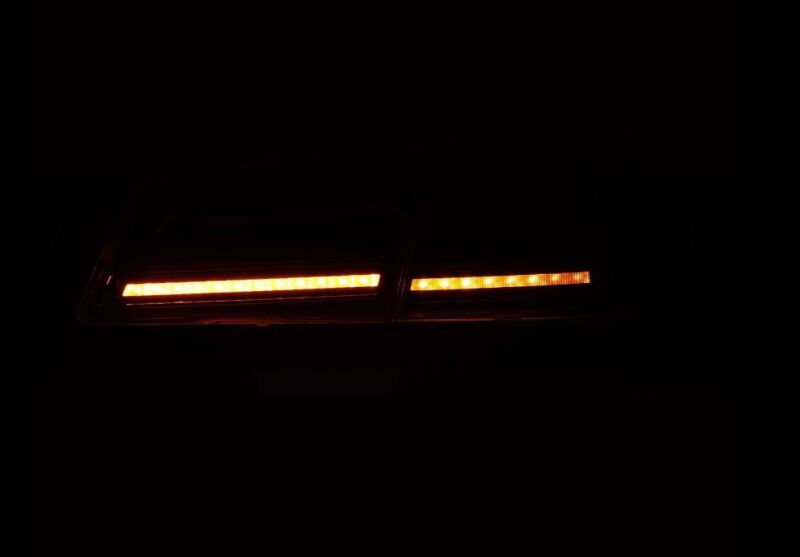AlphaRex LUXX-Series LED tail lights for 12-21 Tesla Model S in Alpha-Black, showcasing bright orange illumination.