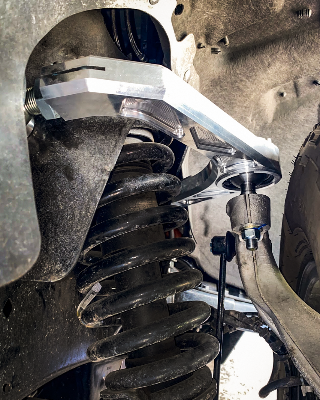 Billet upper control arm kit installed on a 2015-2024 Ford F-150, showcasing stock length and suspension components.