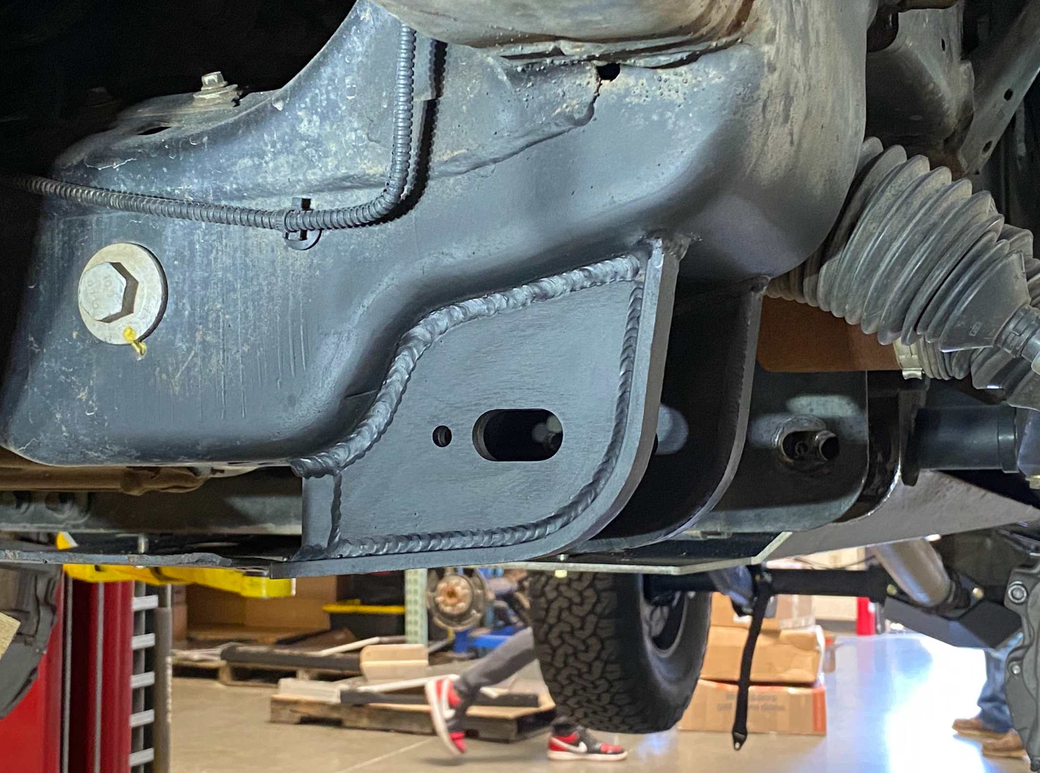 2017-2024 Raptor lower arm pocket replacement kit by Foutz Motorsports installed on a vehicle's undercarriage.