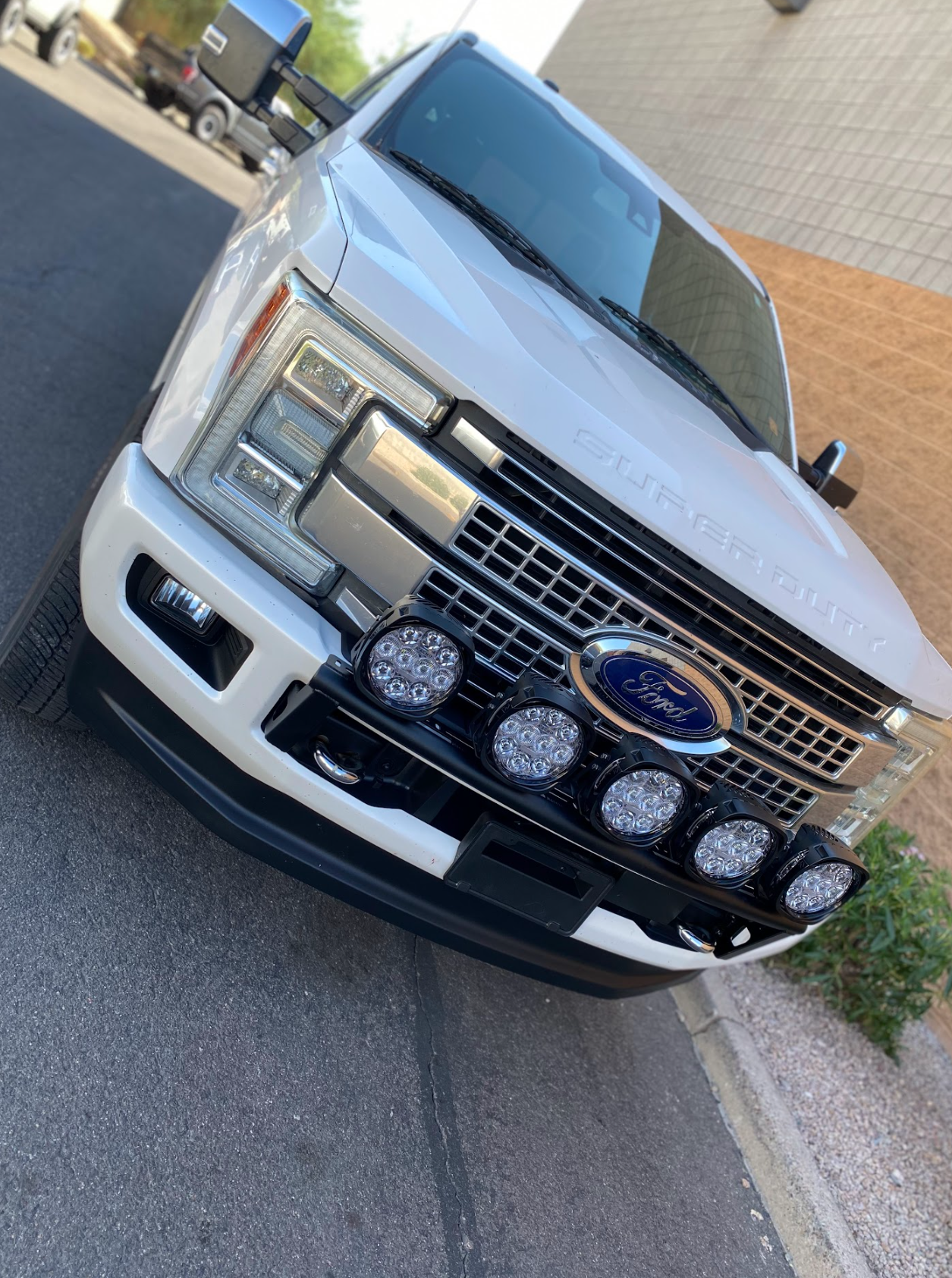 Front view of a 2017-2022 Ford F-250 Super Duty with a Foutz Motorsports front light mount kit installed on the stock bumper.