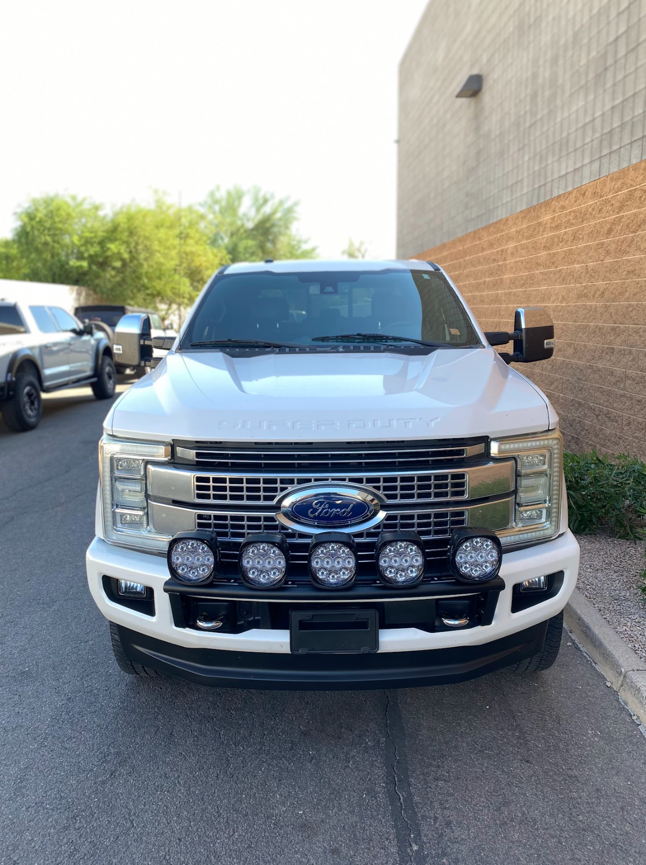 Front view of a 2017-2022 Ford F-250 Super Duty equipped with Foutz Motorsports front light mount kit and multiple off-road lights.