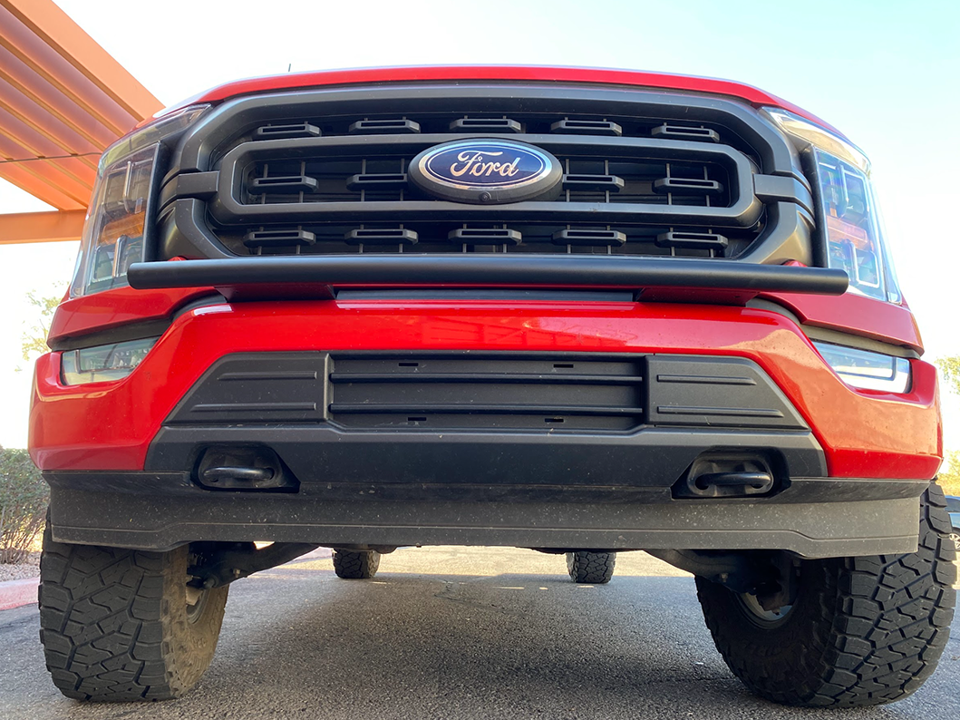 Front view of a red 2021-2023 Ford F150 showcasing a front light mount for the stock bumper, highlighting rugged design.