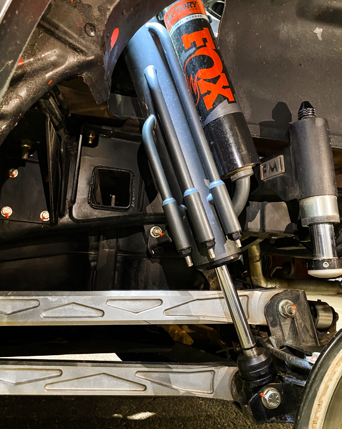 2021+ Raptor 5-Link Rear Bed Organizer showcasing a FOX 3.0x16 coil over shock installed in a truck suspension system.
