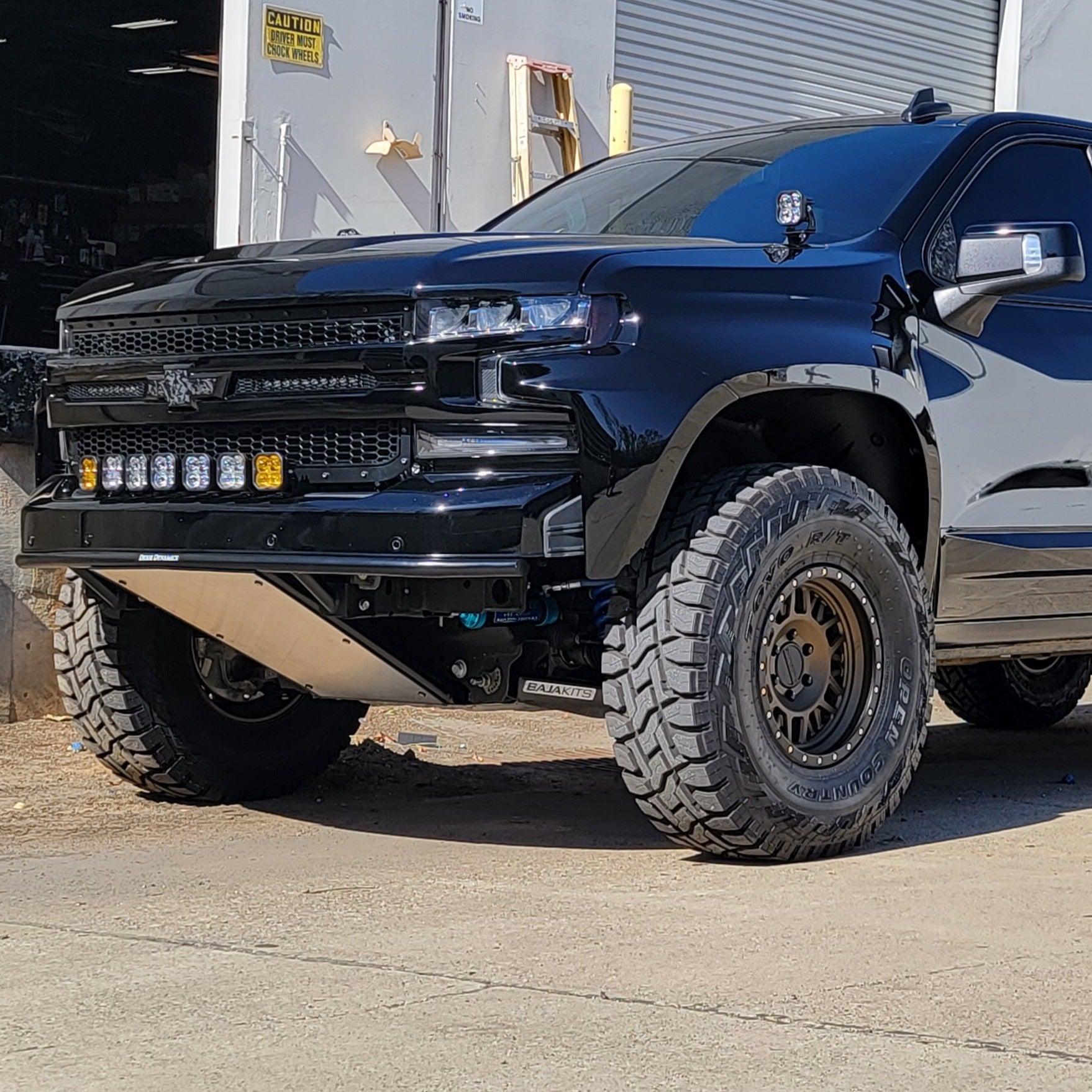 2019-2025 Chevrolet Silverado fenders installed on a modified black truck with off-road tires and LED lights.