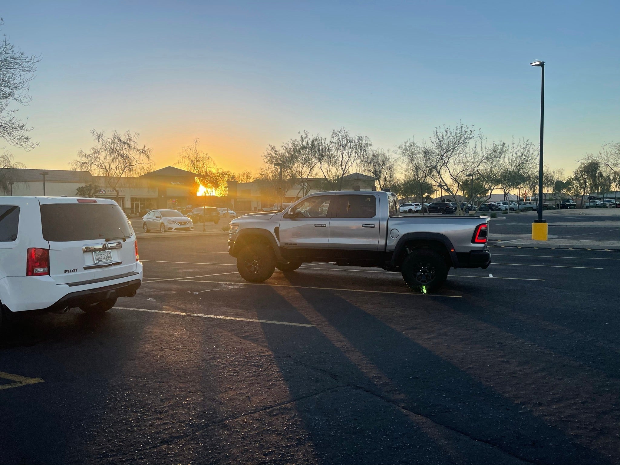 2025 Ram RHO 1.5 inch front leveling kit installed on a silver truck parked at sunset in a lot.