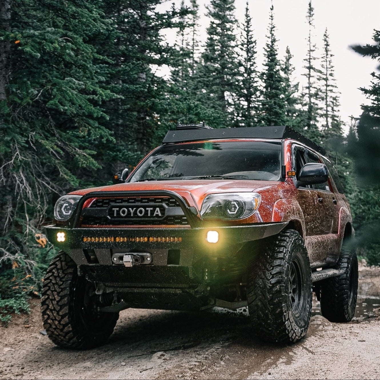4Runner Overland Series front bumper for 2003-2009 models, showcasing rugged design on an off-road vehicle in a forest setting.