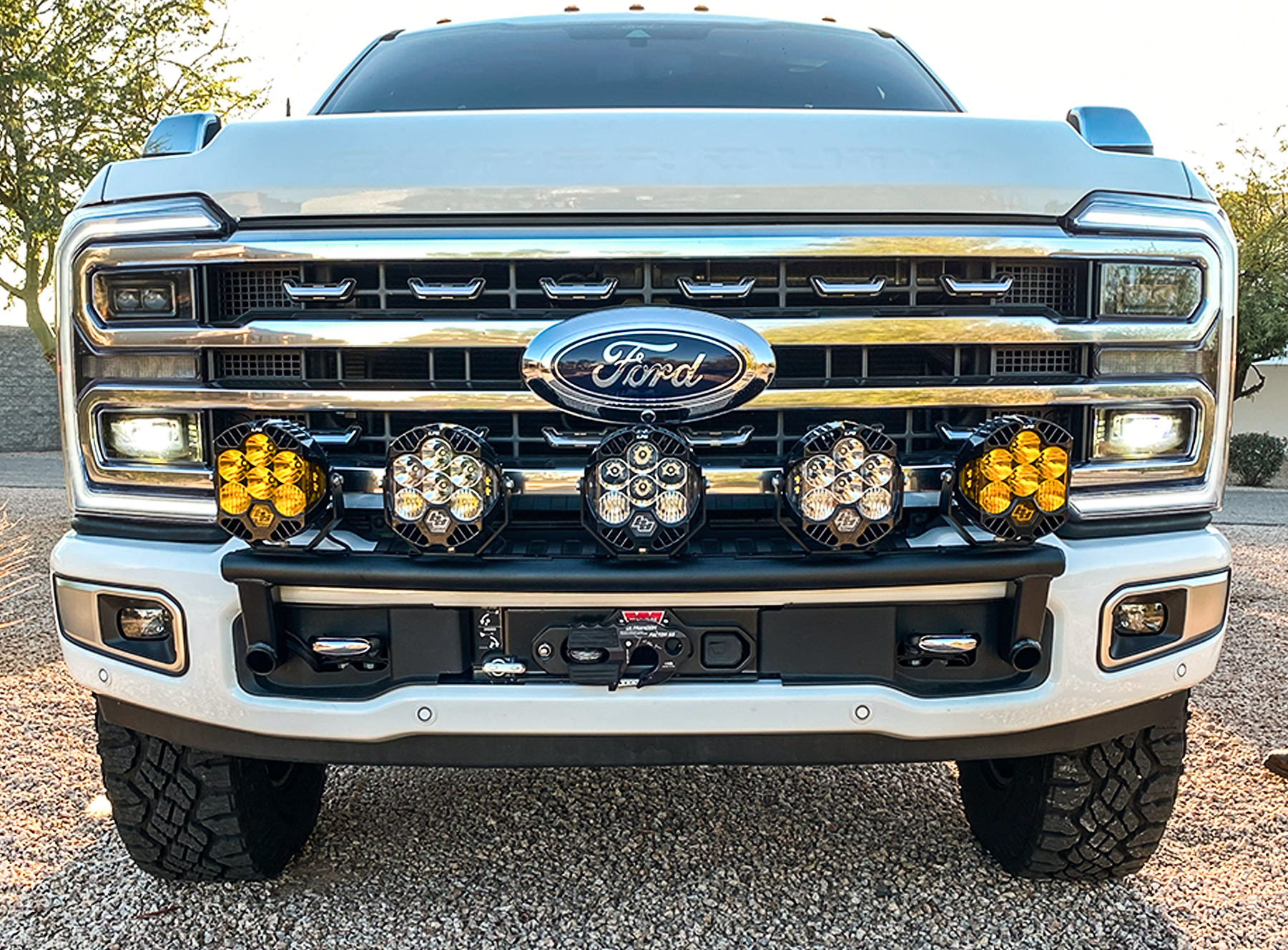2023+ Ford F-250 Super Duty front light mount kit installed on stock bumper, featuring multiple off-road lights for enhanced visibility.