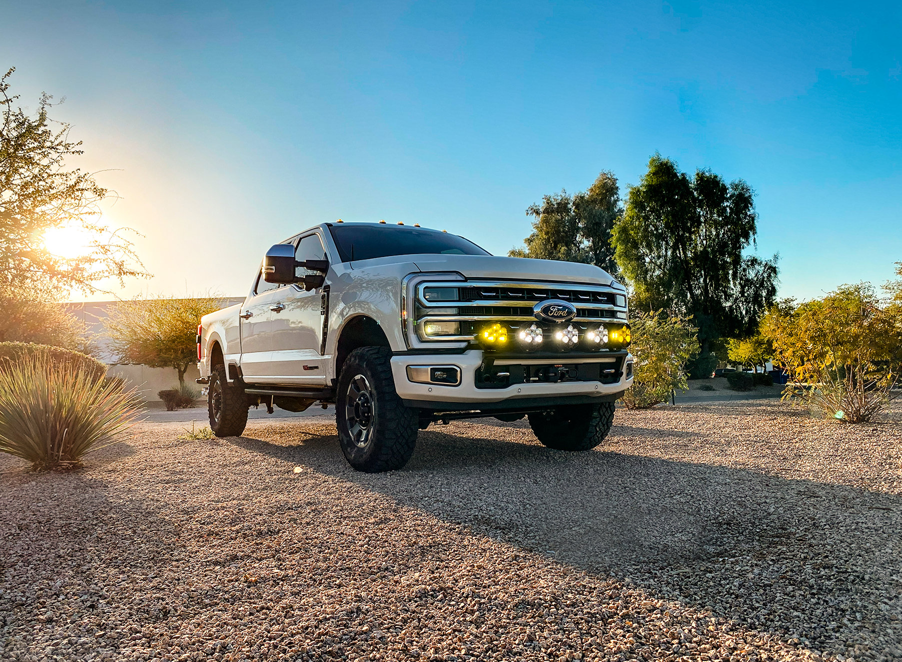 2023+ Ford F-250 Super Duty with front light mount kit installed, showcasing offroad capabilities in a desert setting.