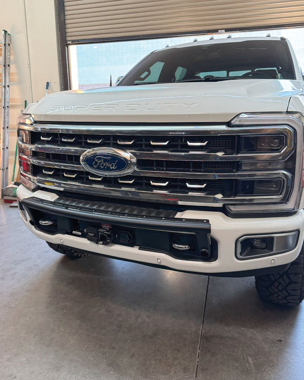 2023+ Ford F-250 Super Duty front light mount kit installed on stock bumper, showcasing a rugged and functional design.