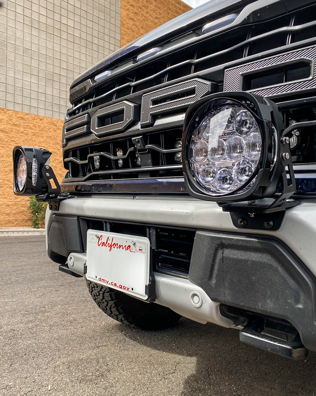 Light mount brackets for 2024+ Gen 3.5 Raptor, designed for stock bumpers, showcasing two mounted lights.