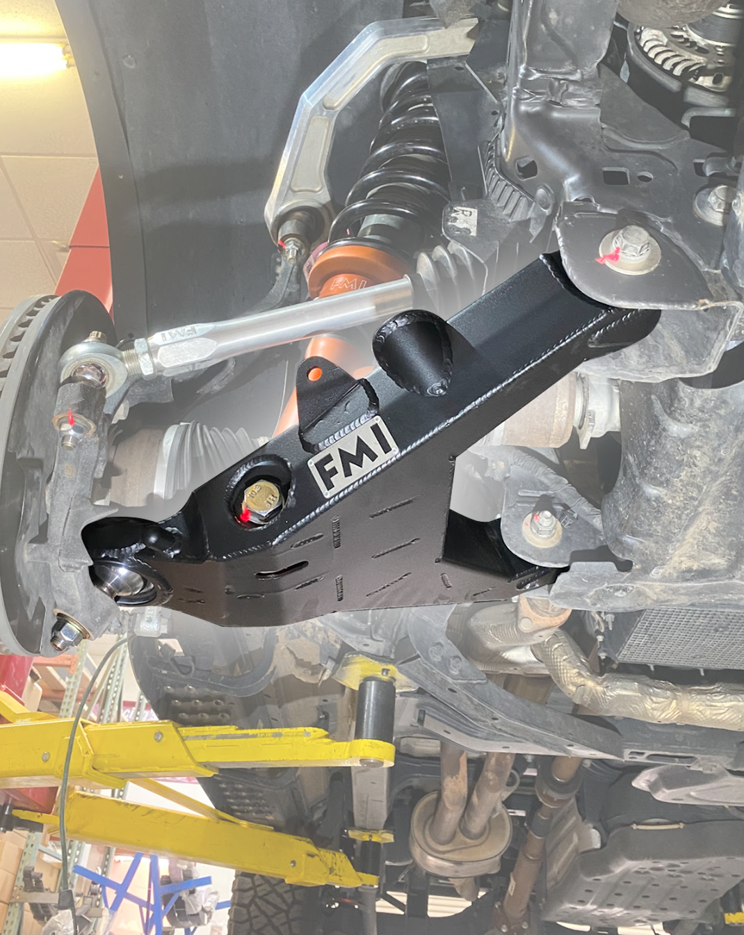 2024+ Ranger Raptor fabricated lower A-arm kit displayed under a vehicle, showcasing its stock width and robust design.