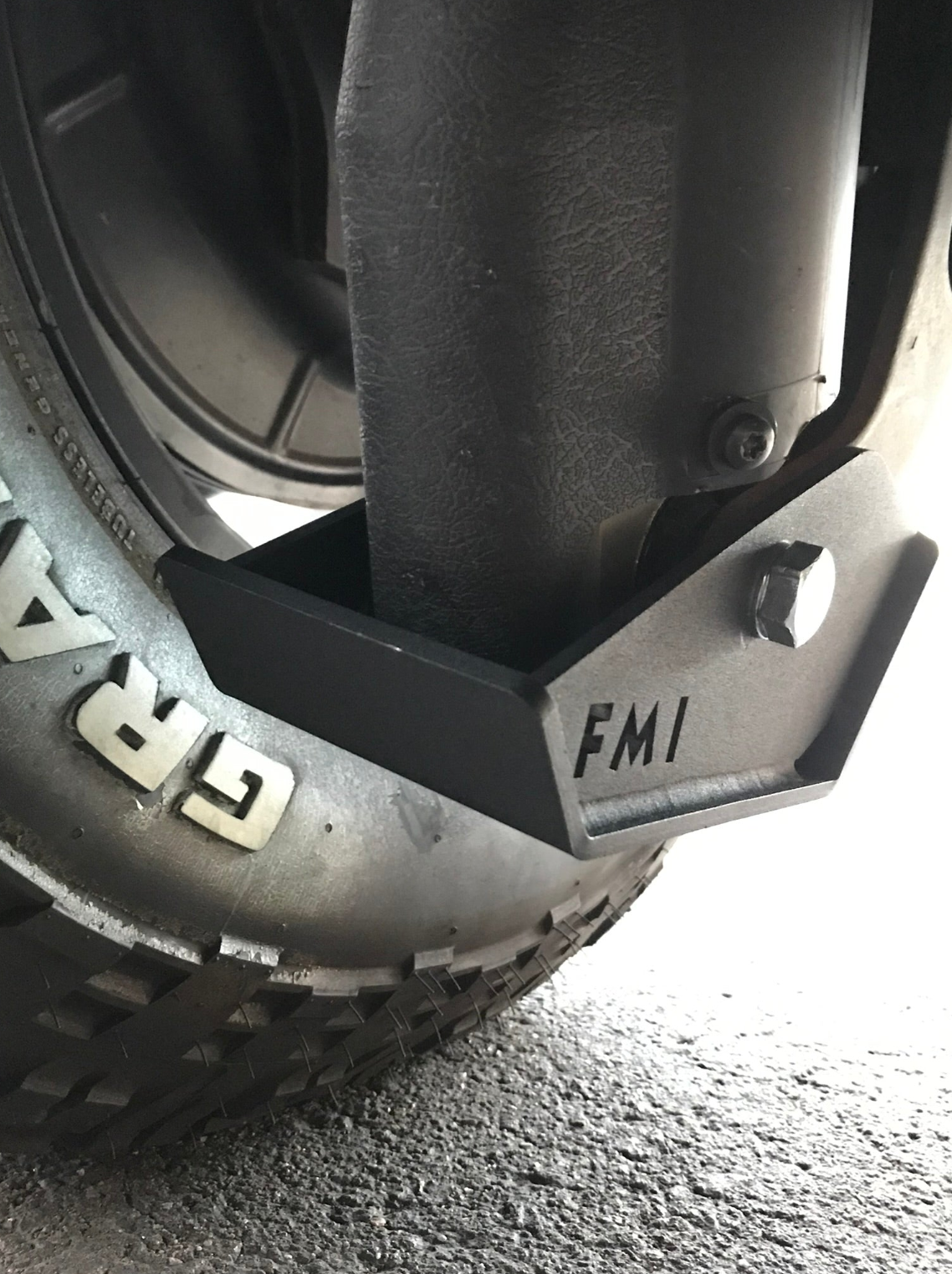 2025 Ram RHO Rear Shock Skid Kit mounted on a tire, showcasing durable metal construction for off-road protection.