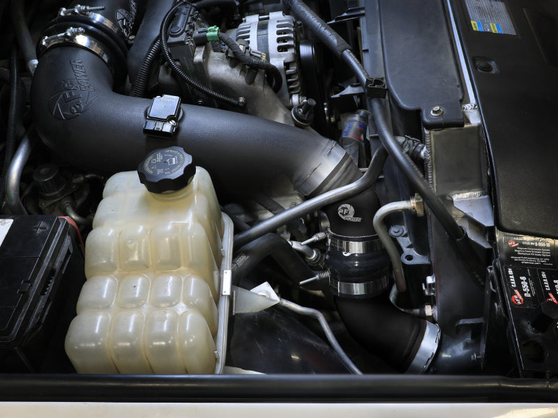 Afe BladeRunner charge pipe installed in a GM diesel truck engine bay, showcasing components for enhanced performance.