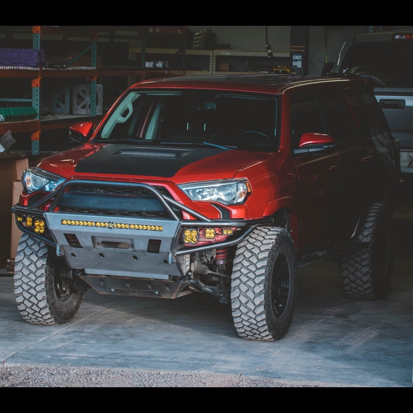 4Runner Hybrid Front Bumper for 5th Gen models (2014-2024) installed on a red SUV, showcasing rugged off-road design.