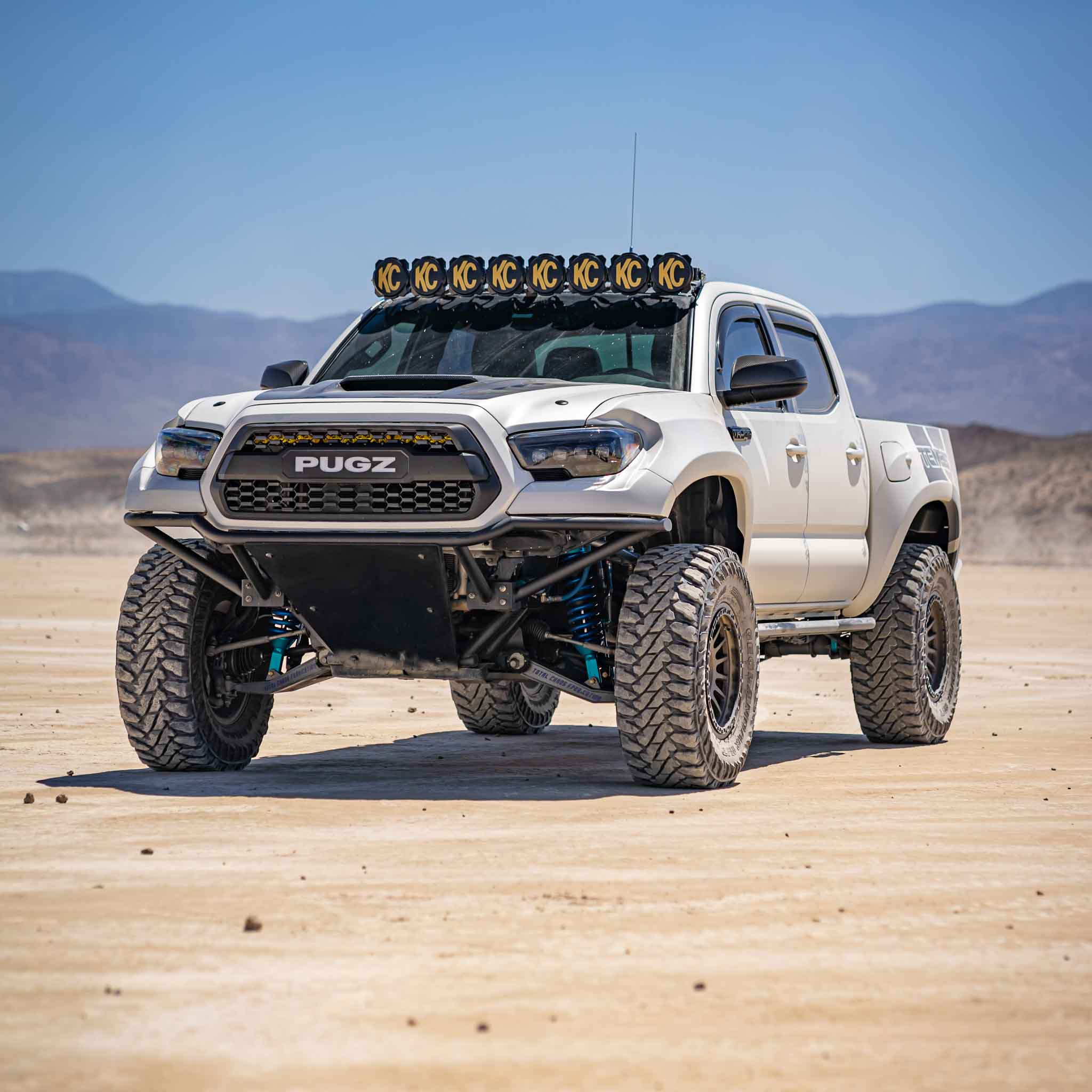 2016-2023 Toyota Tacoma with custom fenders and offroad tires, showcasing rugged design in a desert landscape.