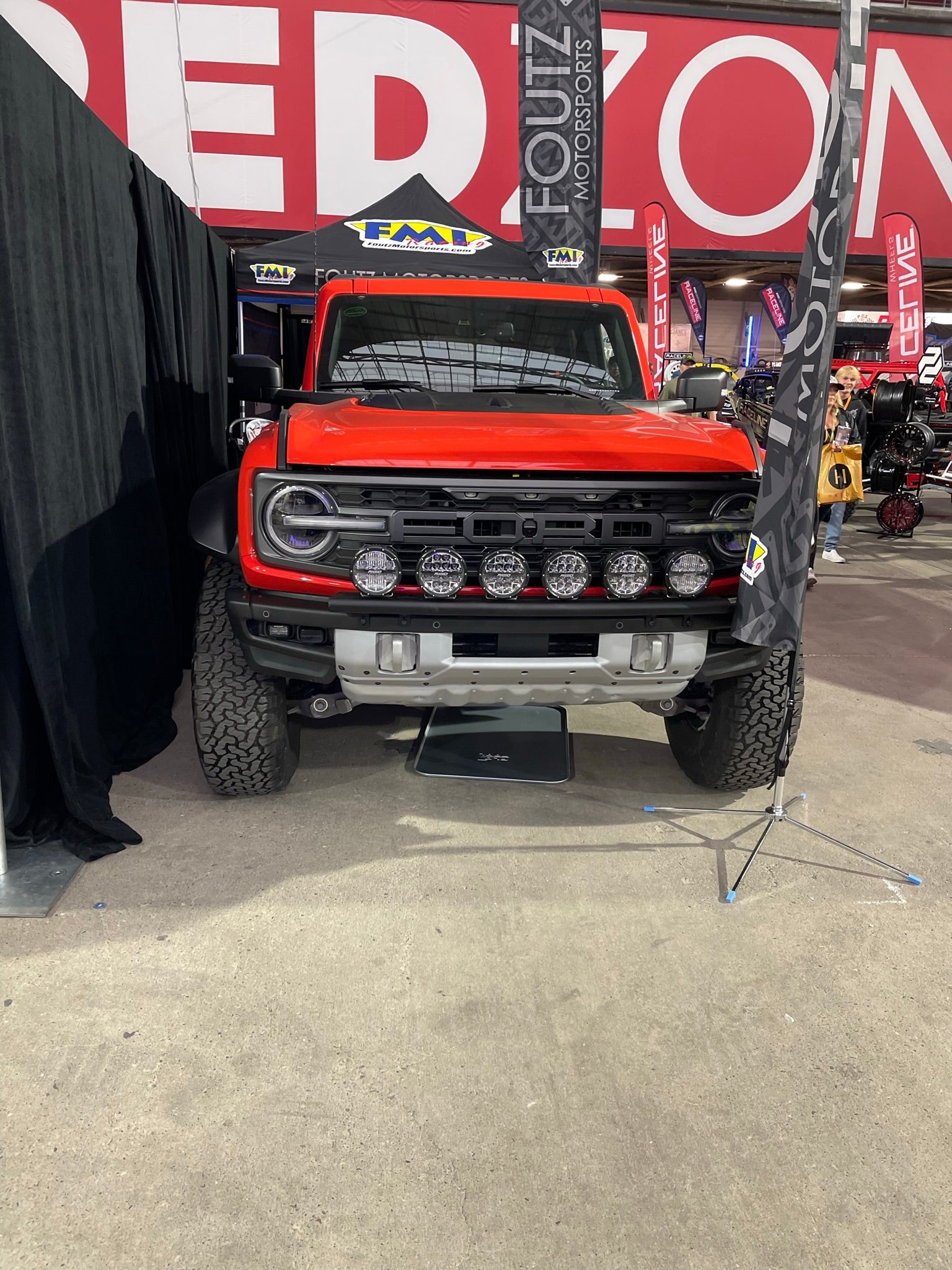 2022-UP Bronco Raptor Front Light Mount Kit displayed on a red Bronco with multiple lights mounted on the front.