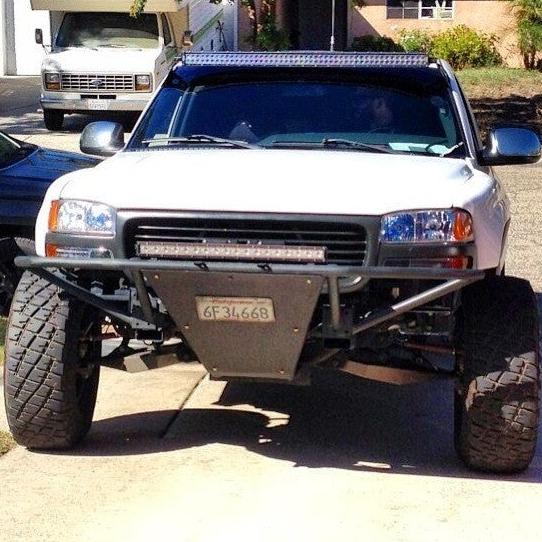Front view of a modified GMC Sierra showcasing aftermarket fenders designed for 2000-2006 models.