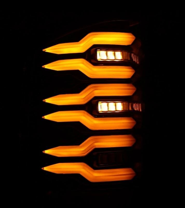 AlphaRex LUXX-Series LED tail lights for 2007-2013 Chevrolet Silverado 1500 in alpha-black finish, showcasing bright amber lighting.