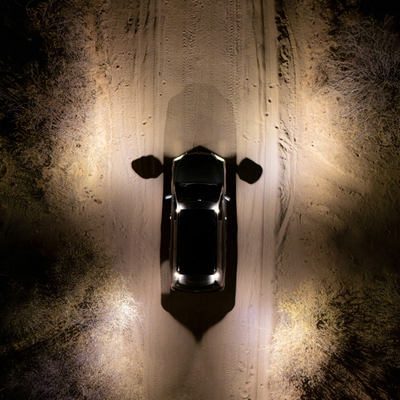 ARB Nacho Nano Base Rack Corner Cap 4-Light Kit illuminating a vehicle on a dirt road at night, showcasing offroad capabilities.