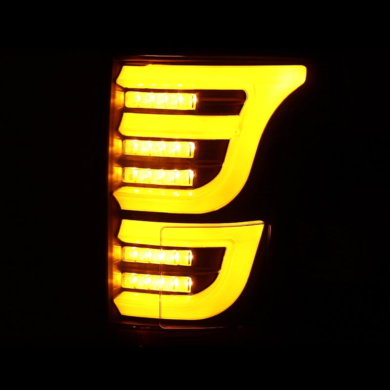AlphaRex Luxx-Series LED tail lights for 15-20 Ford F150 in alpha-black with bright amber illumination.