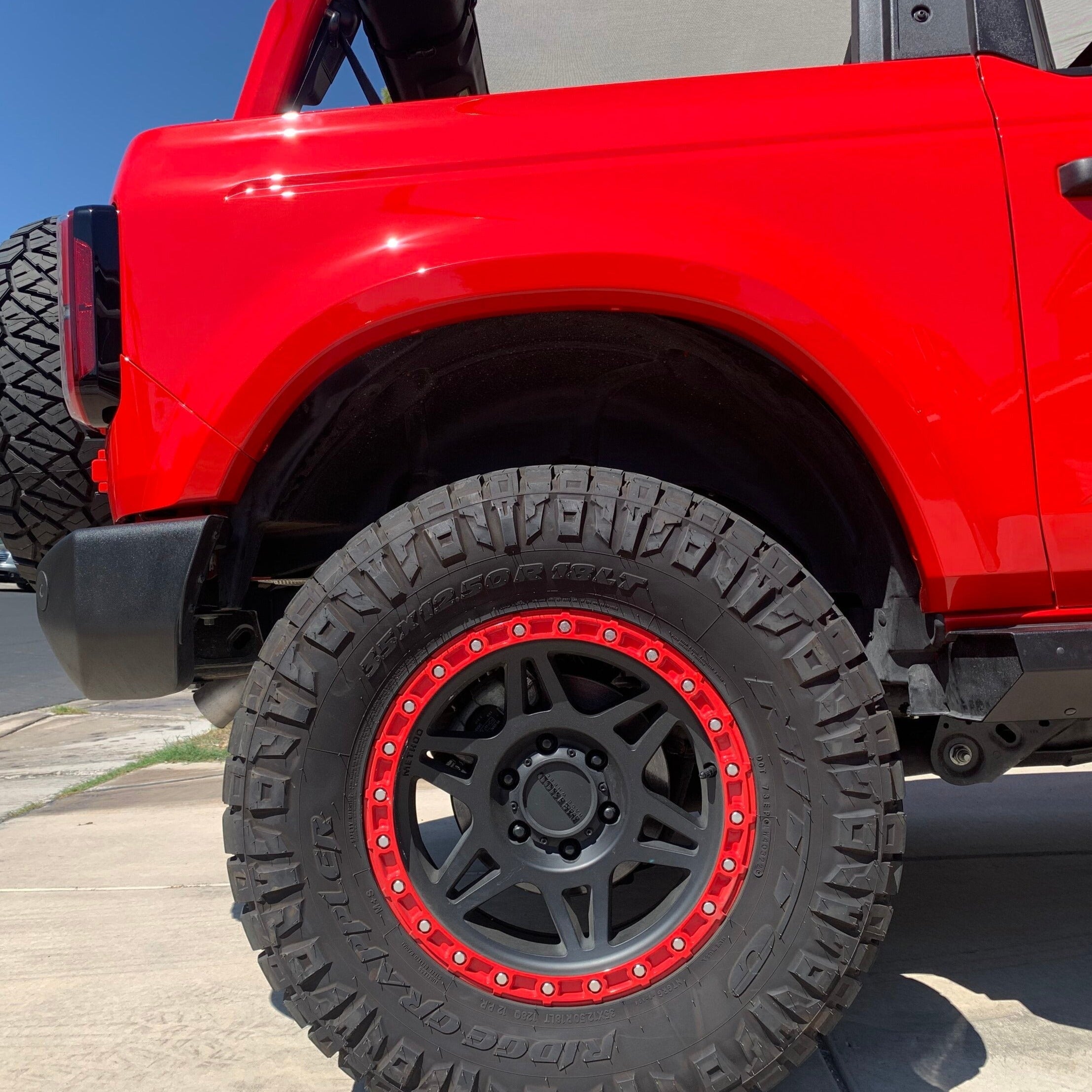 2021-2025 Ford Bronco 2-Door Rear Quarter Kit showcasing a red SUV with rugged tires and a stylish wheel design.