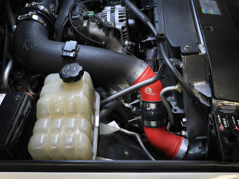 Afe BladeRunner Charge Pipe Kit installed in a GM Diesel truck engine bay, featuring red and black piping for enhanced airflow.