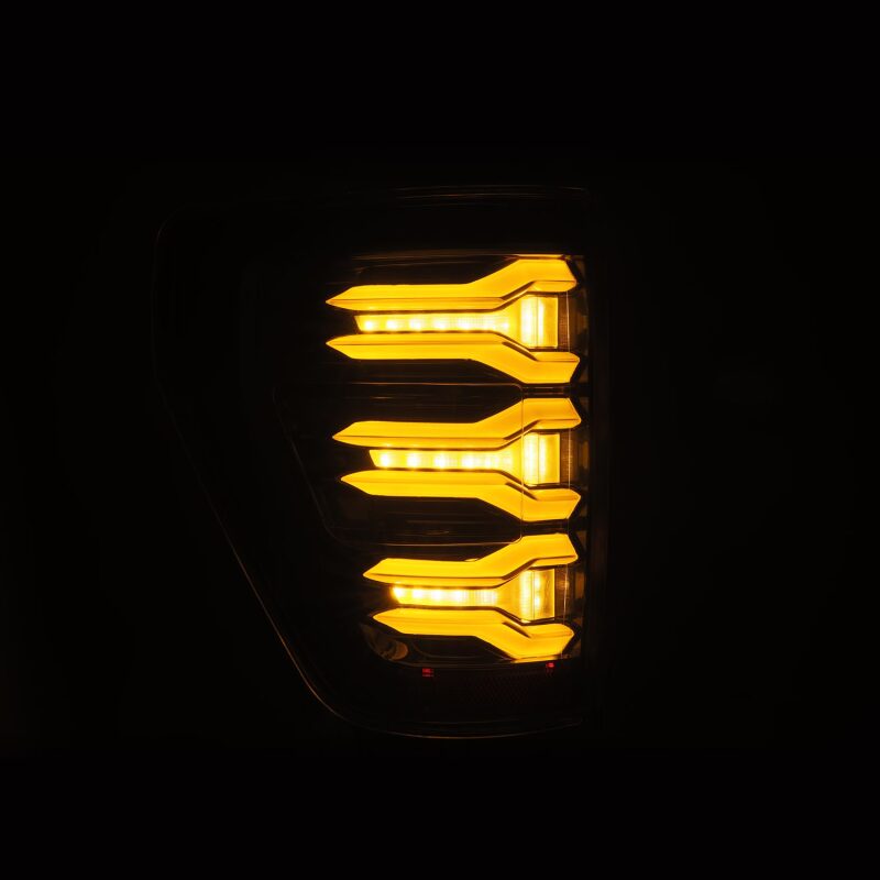 AlphaRex LUXX LED projector tail lights for 2021-2022 Ford F150 in alpha-black with bright amber LED design.