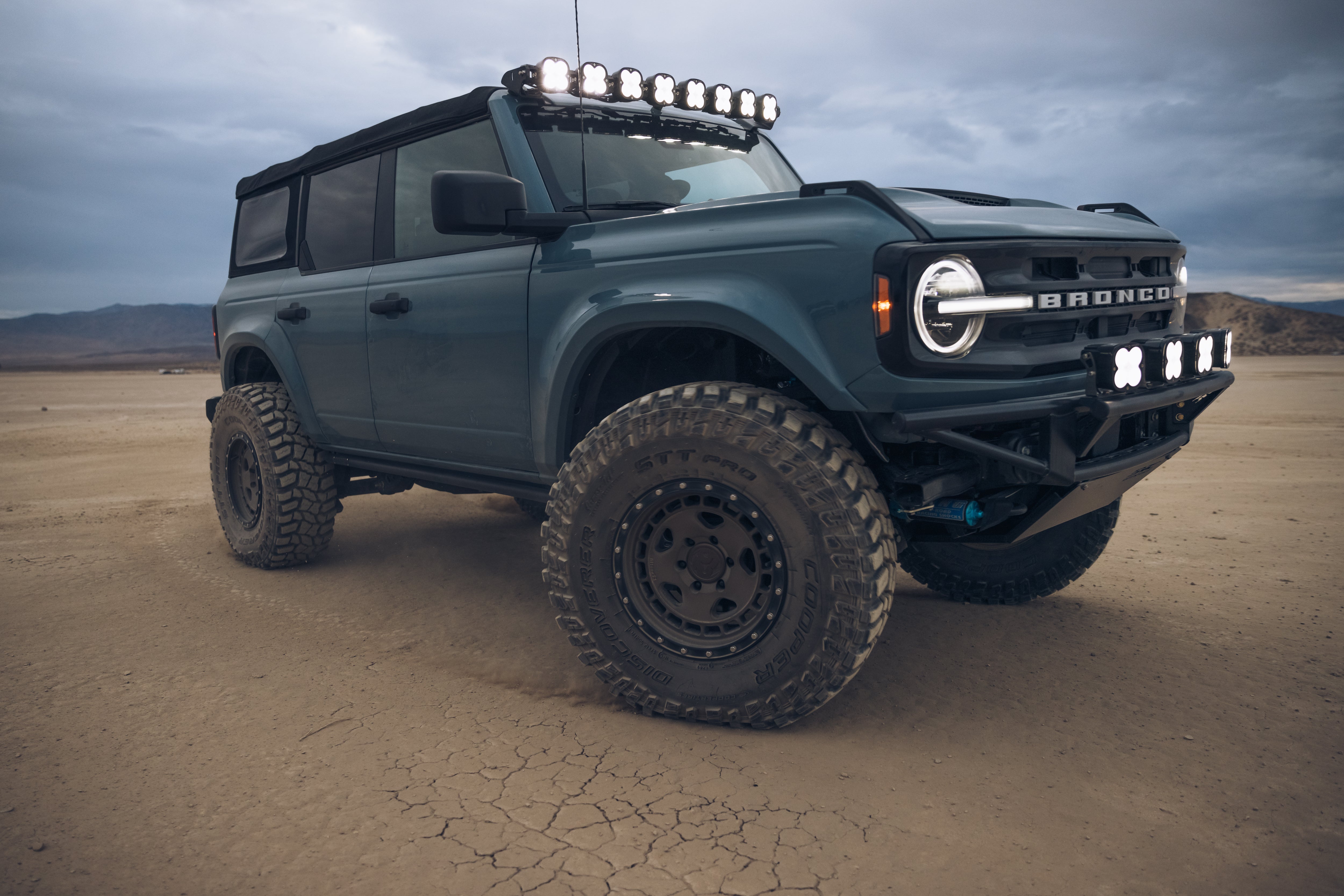ADV Fiberglass 2021 Ford Bronco with offroad tires and LED light bar, set against a rugged desert landscape.