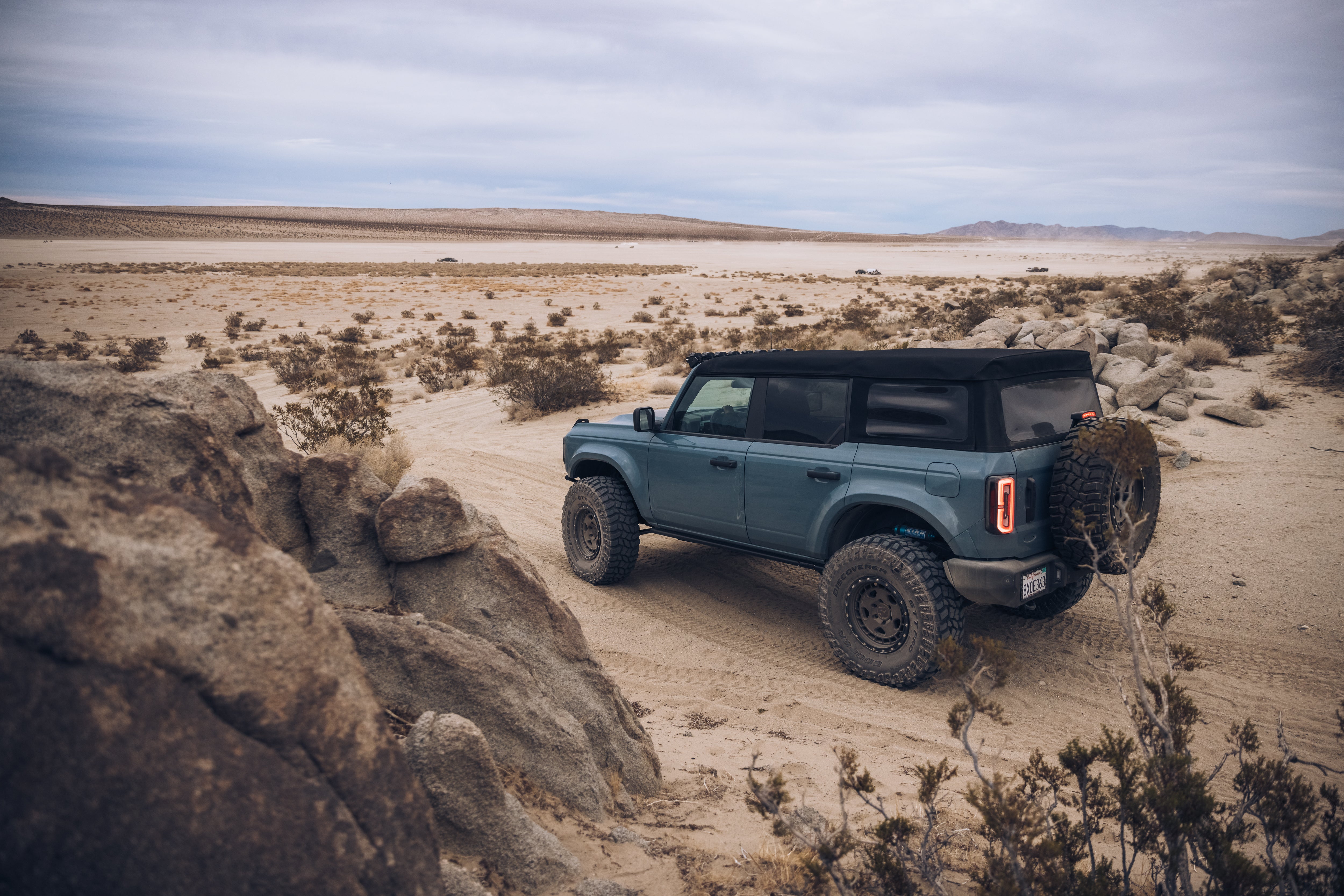 ADV Fiberglass 2021 Ford vehicle off-roading in a desert landscape, showcasing rugged terrain and adventure-ready design.