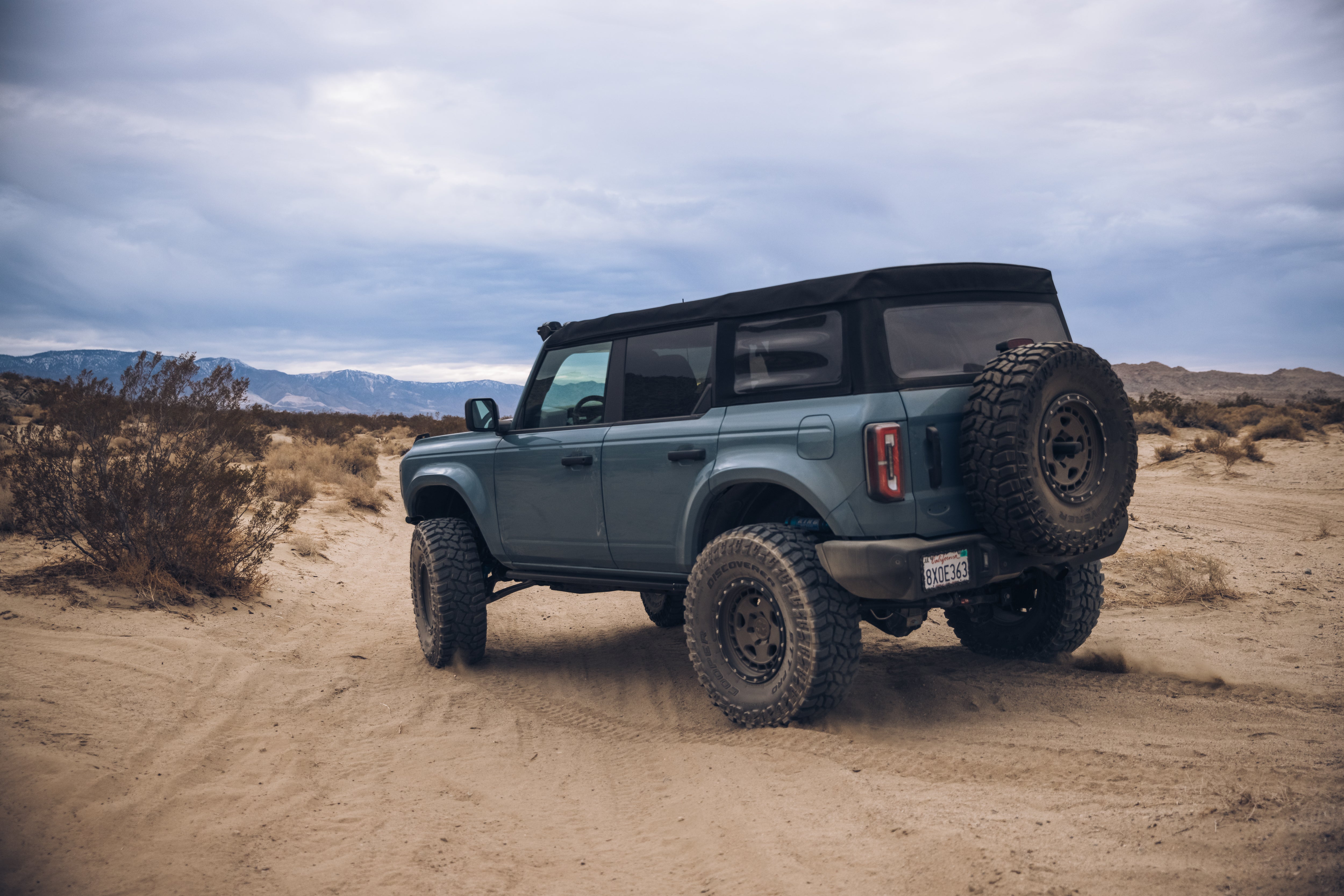 2021 Ford Bronco with ADV fiberglass body kit in a desert landscape, showcasing off-road capabilities and rugged design.